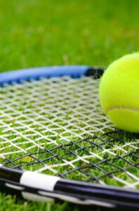 Tennis racquet and ball on grass court - image to go with Wimbledon blog post on read2write.com