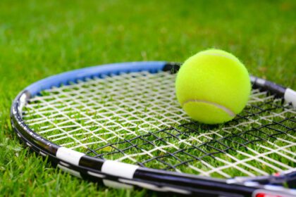 Tennis racquet and ball on grass court - image to go with Wimbledon blog post on read2write.com