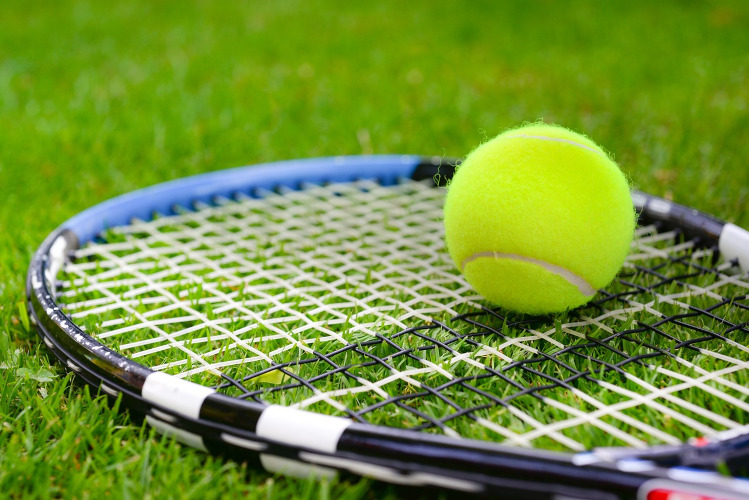 Tennis racquet and ball on grass court - image to go with Wimbledon blog post on read2write.com